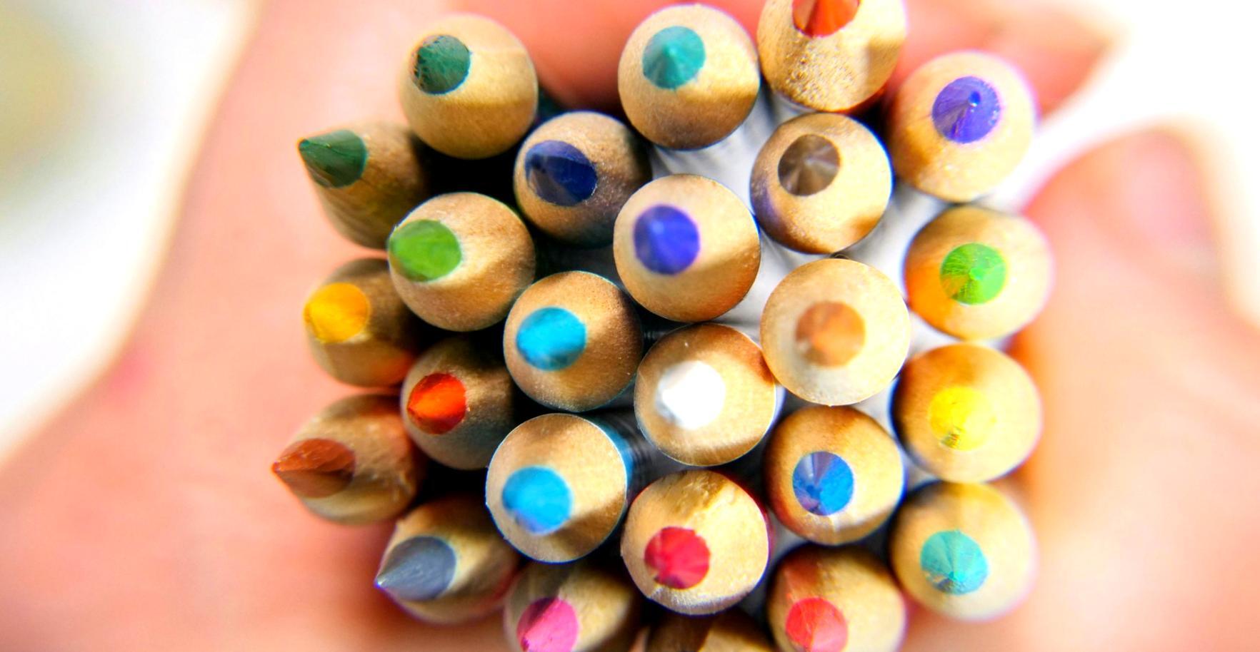 Tavolo da lavoro con materiali per il disegno e schizzi di ritratti in corso d'opera